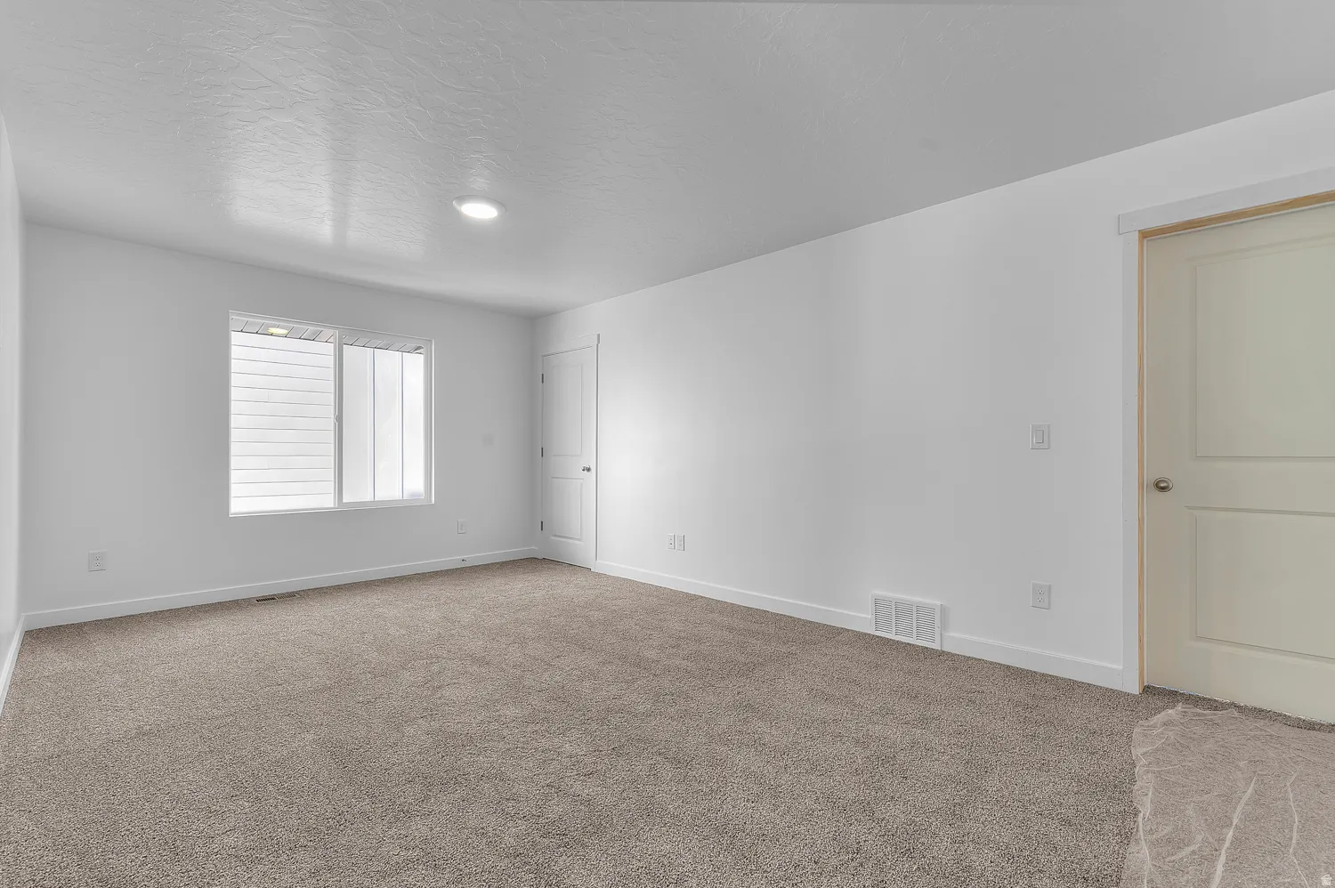Carpeted spare room with baseboards and a textured ceiling