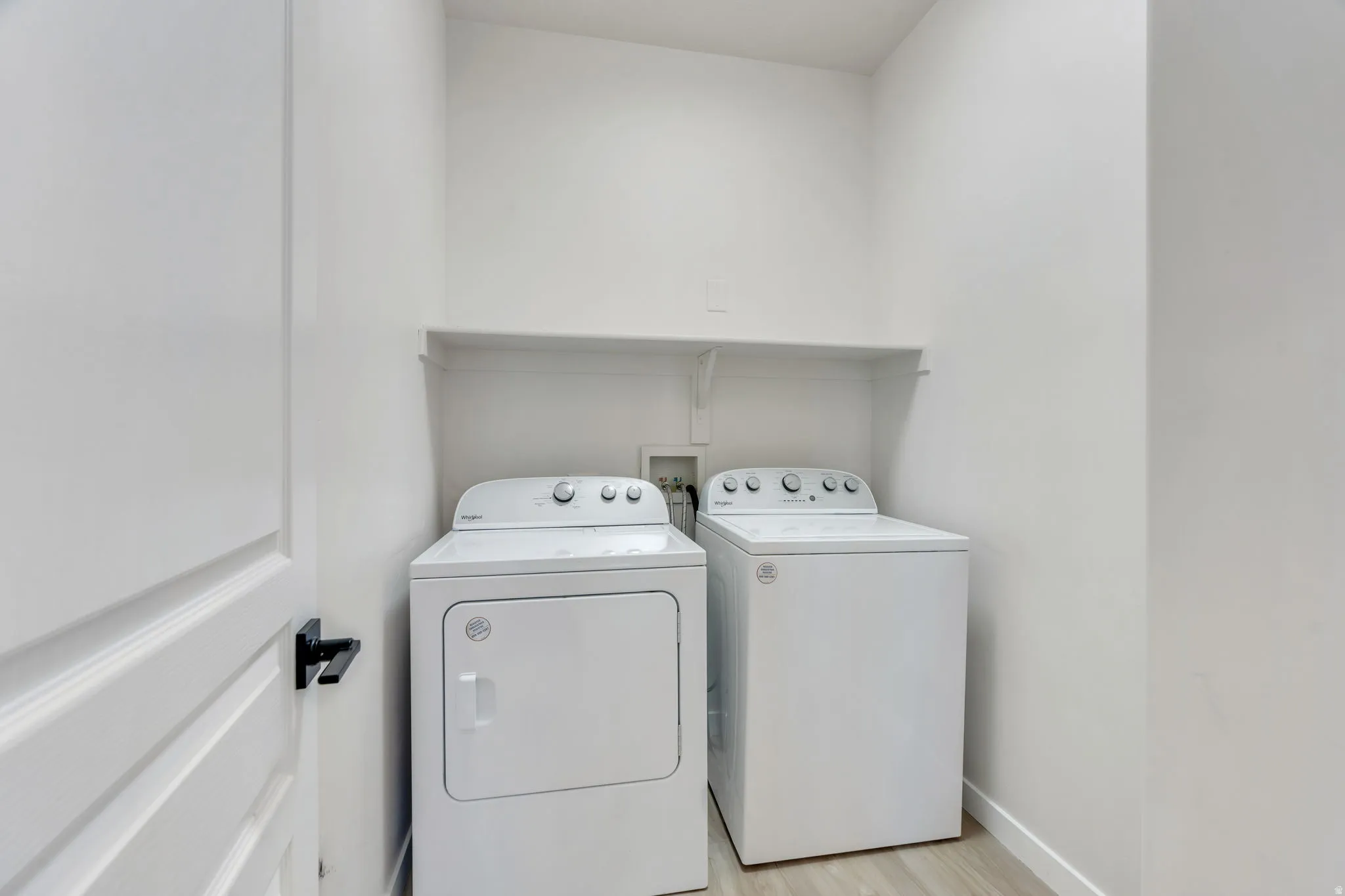 Laundry area featuring separate washer and dryer and light wood-style floors