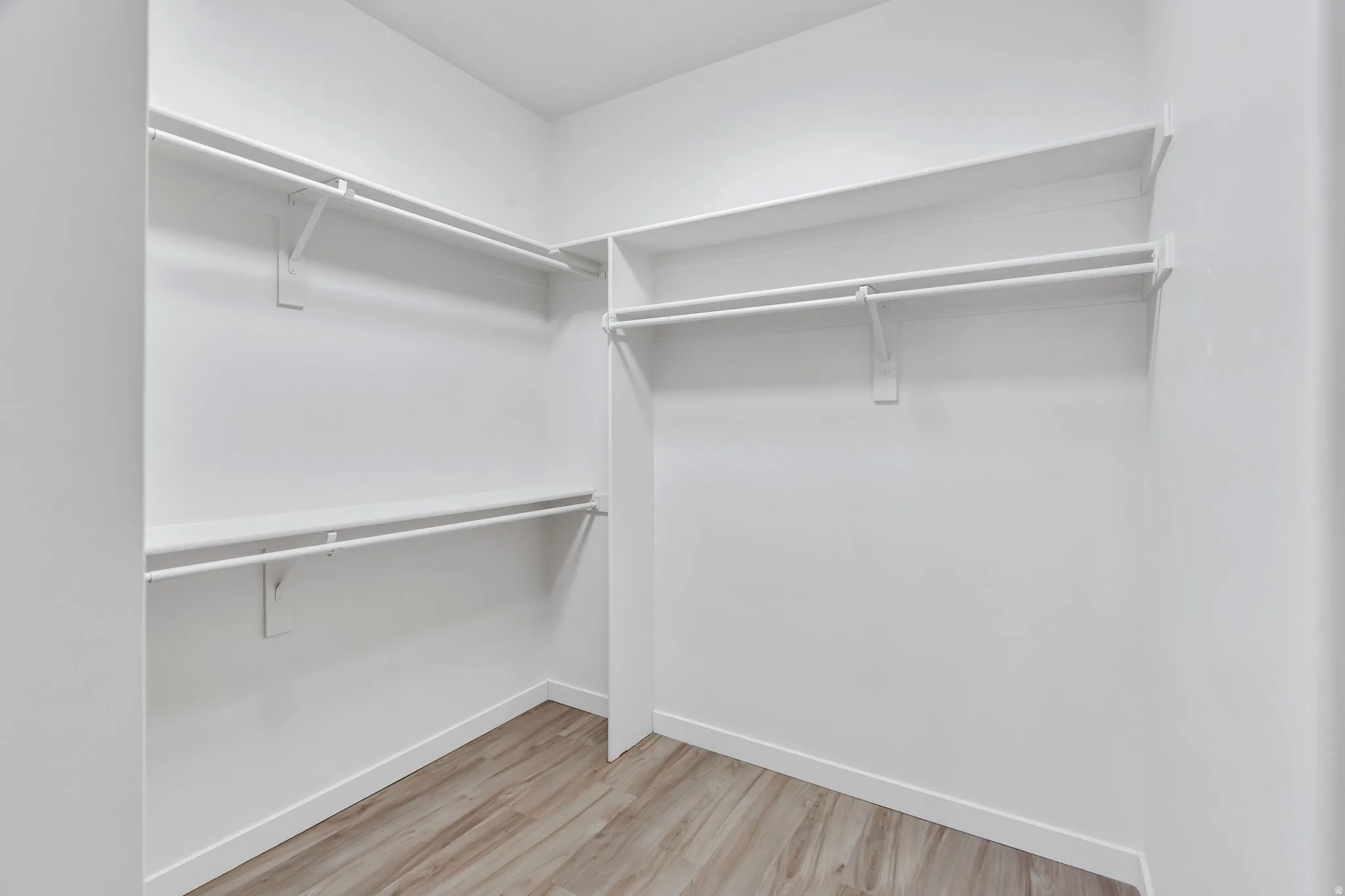 Walk in closet with light wood-style flooring
