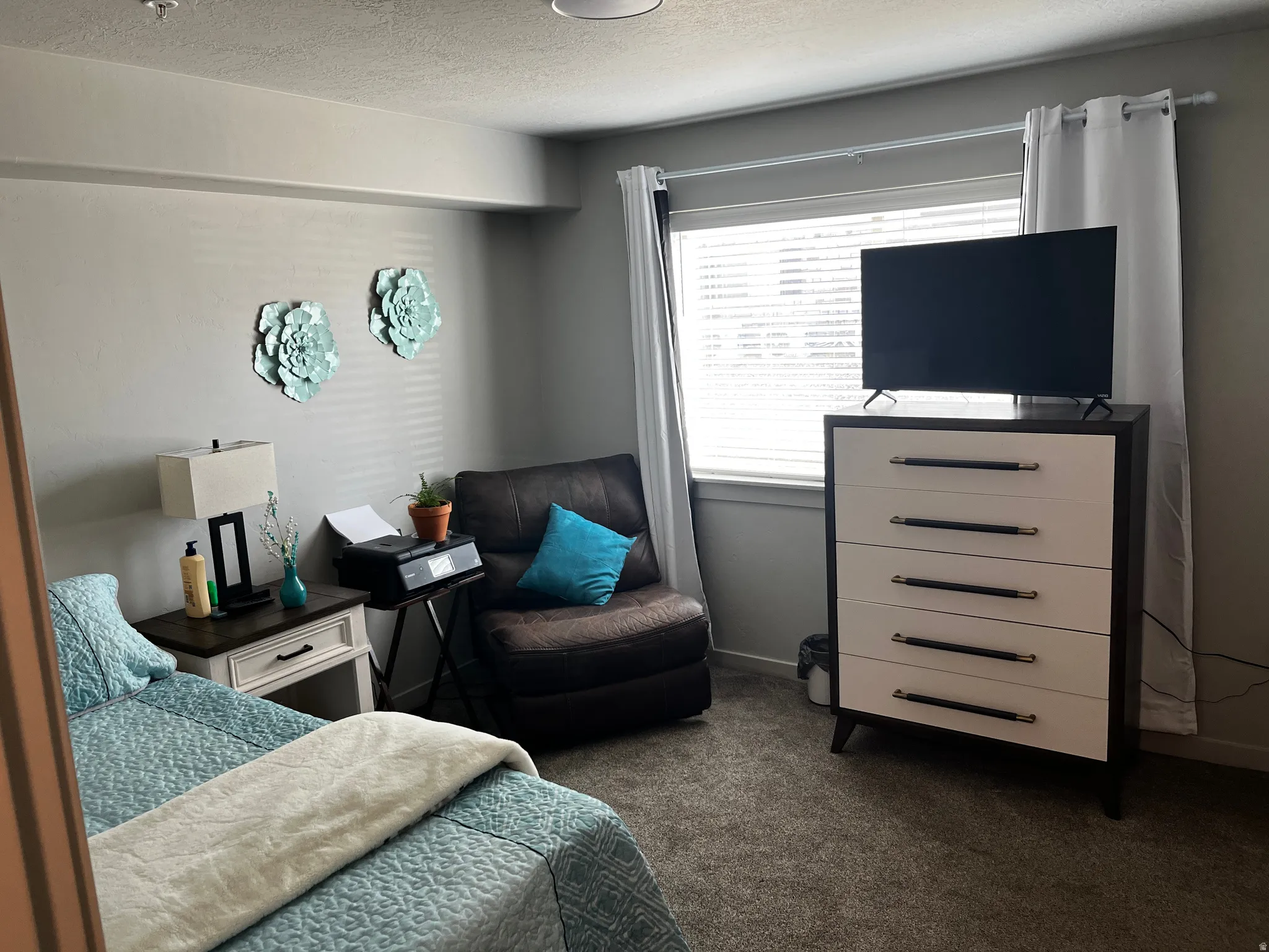 Bedroom featuring a textured ceiling and dark carpet