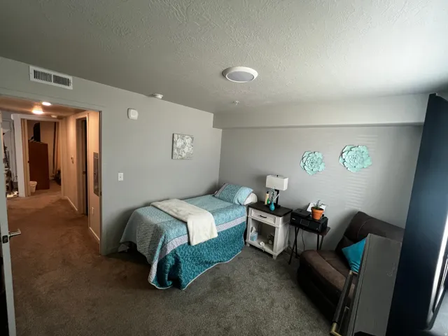 Bedroom featuring a textured ceiling and dark carpet