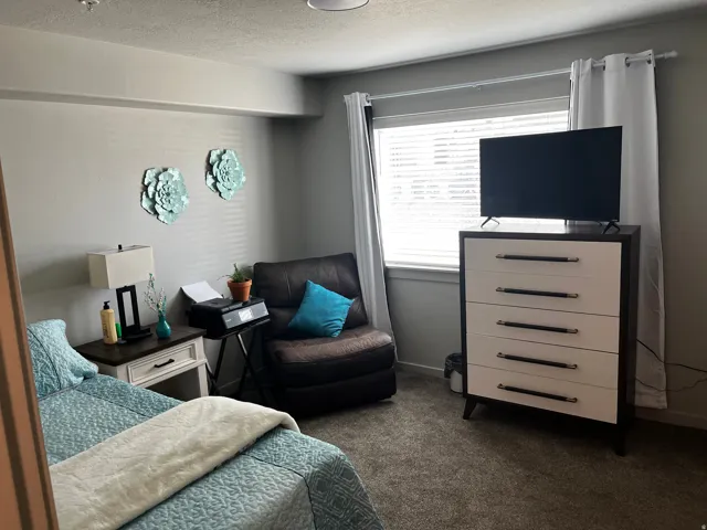 Bedroom featuring a textured ceiling and dark carpet