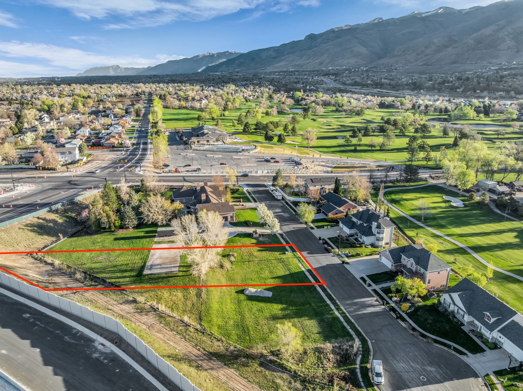 Aerial perspective of suburban area featuring property boundaries highlighted and a mountain backdrop