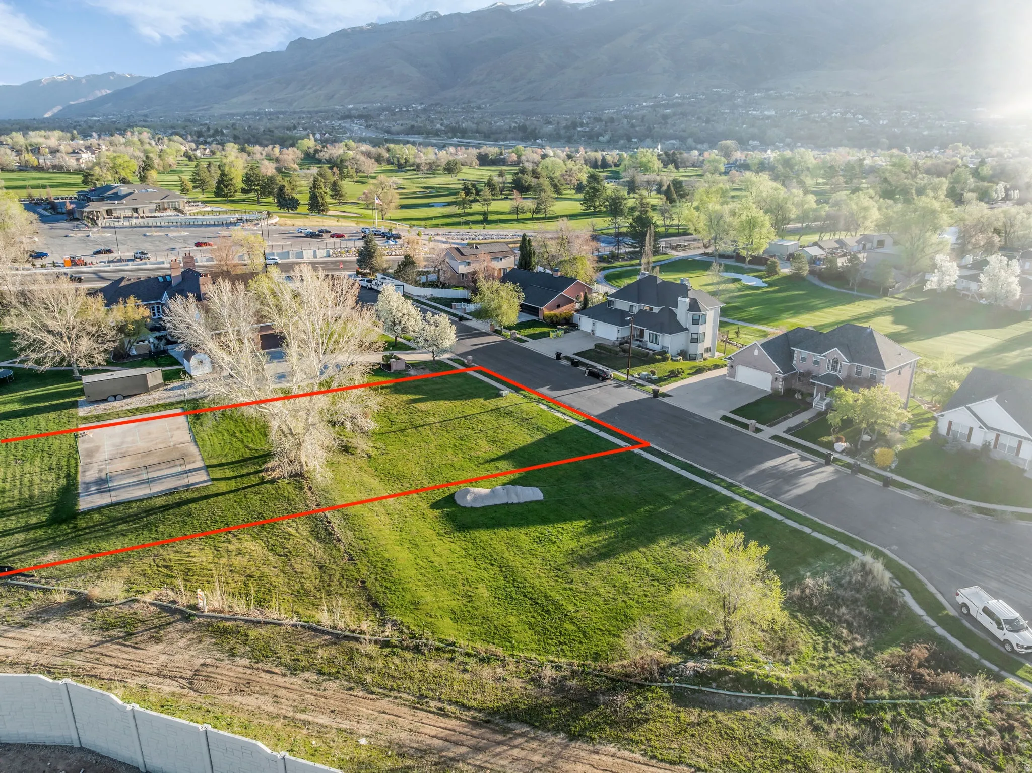 Aerial view of residential area featuring property parcel outlined and a mountain backdrop