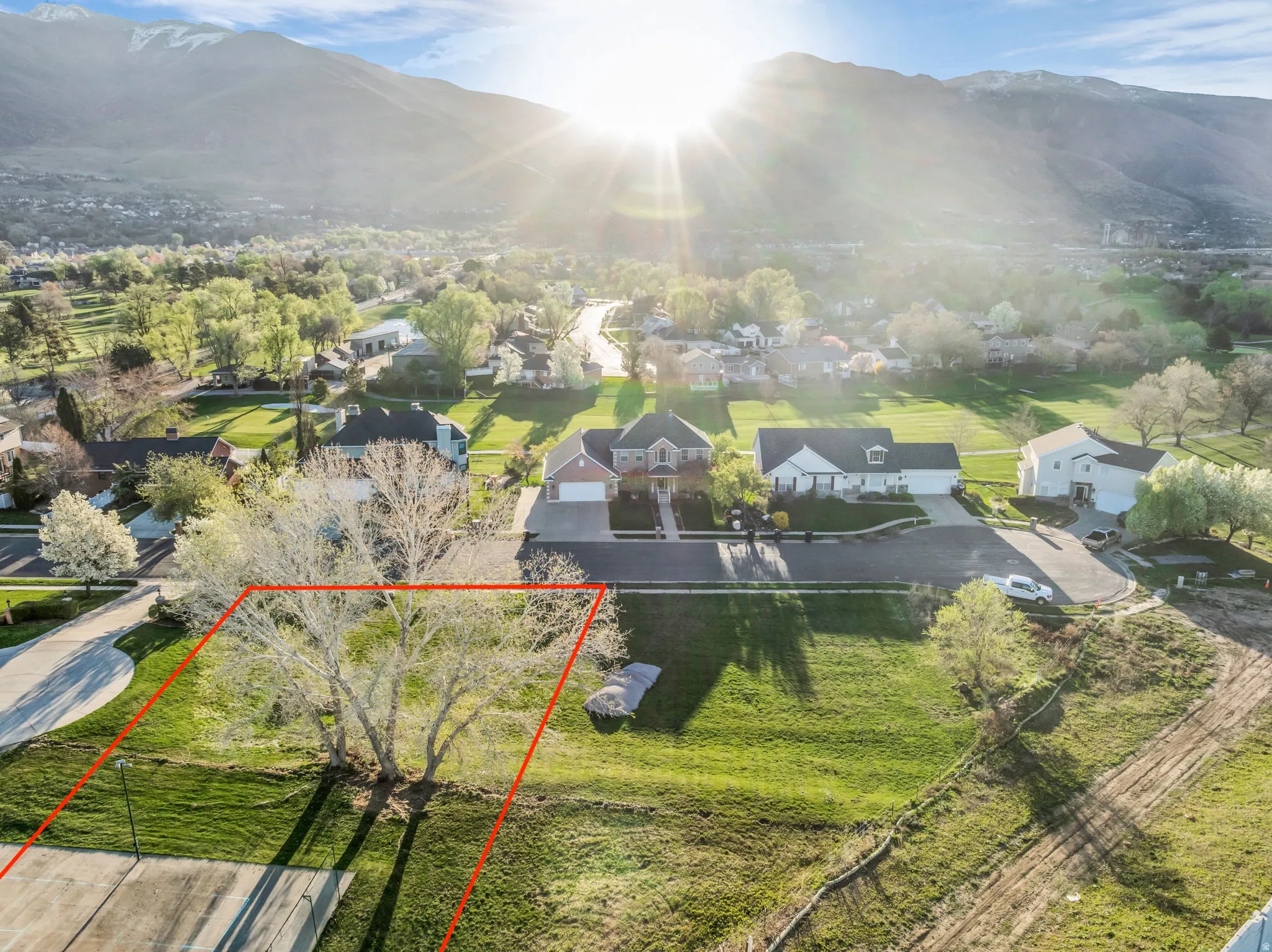 Aerial view of residential area featuring property boundaries highlighted and mountains