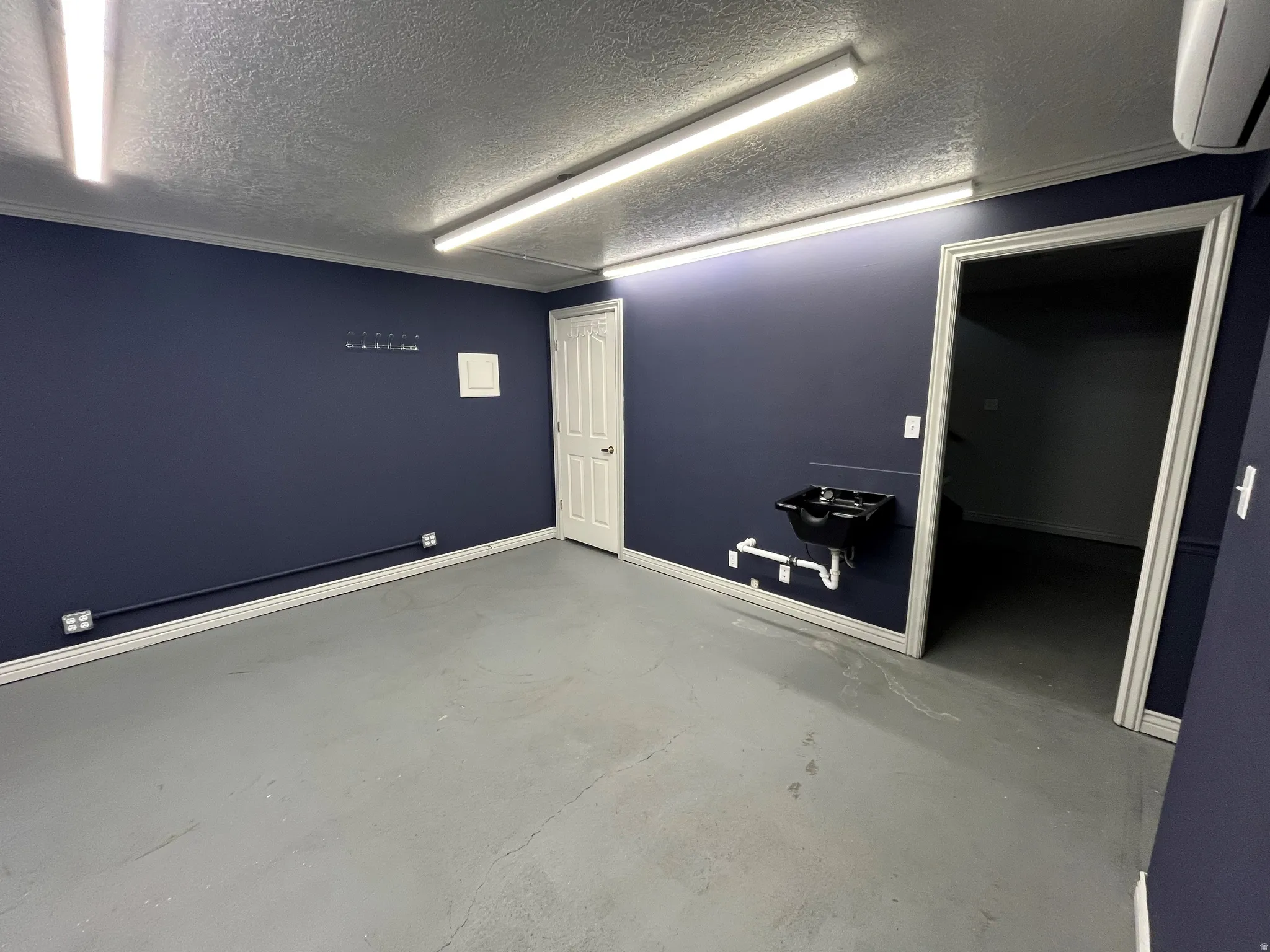 Unfurnished room featuring concrete floors and a textured ceiling