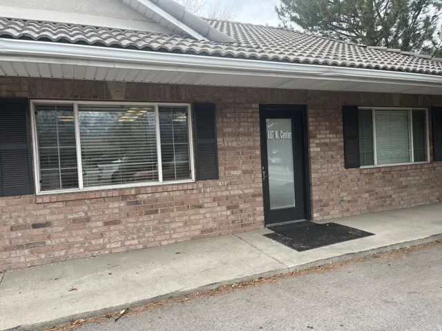 Entrance to property with a tiled roof and brick siding