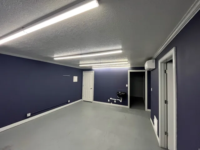 Spare room with finished concrete floors, a textured ceiling, and crown molding