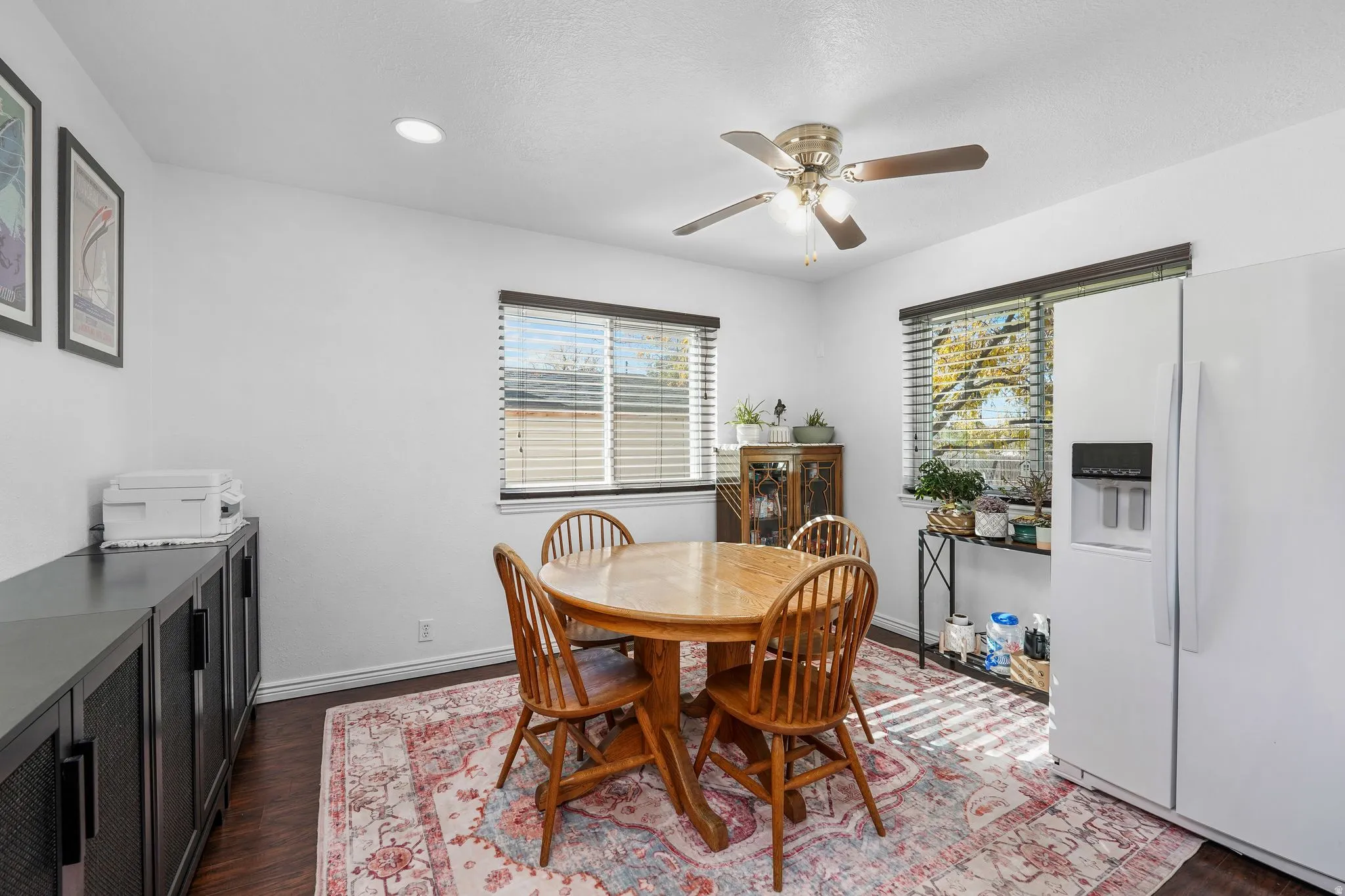 Dining room with dark wood-type flooring, a ceiling fan, and recessed lighting