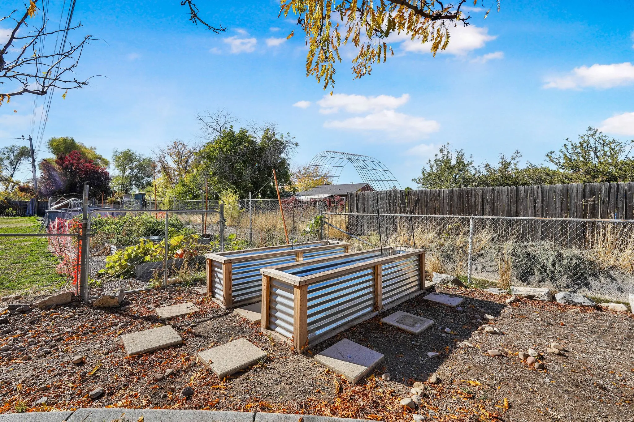 Fenced backyard featuring a vegetable garden