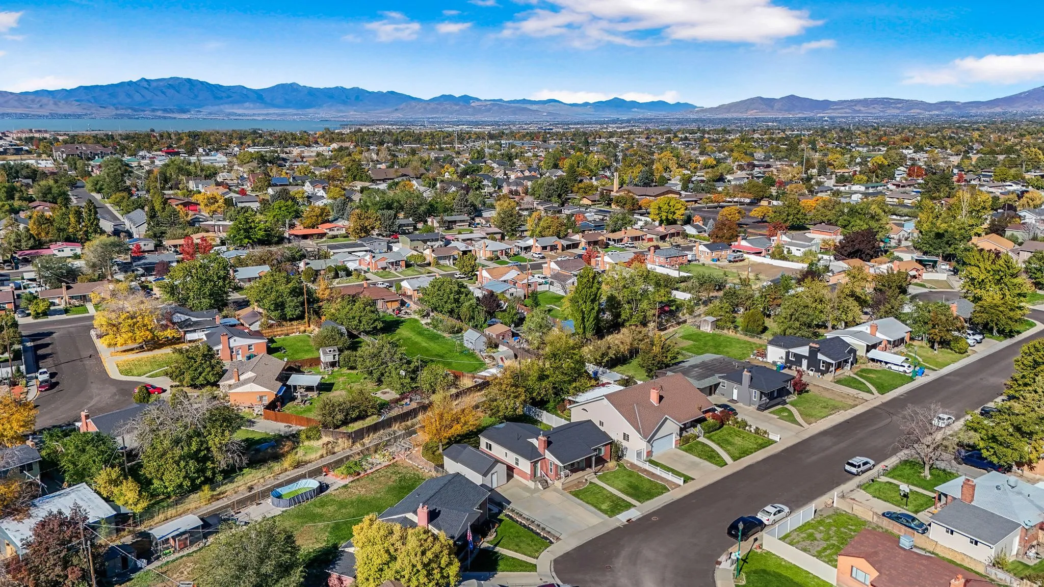 Aerial view of property and surrounding area with mountains and nearby suburban area