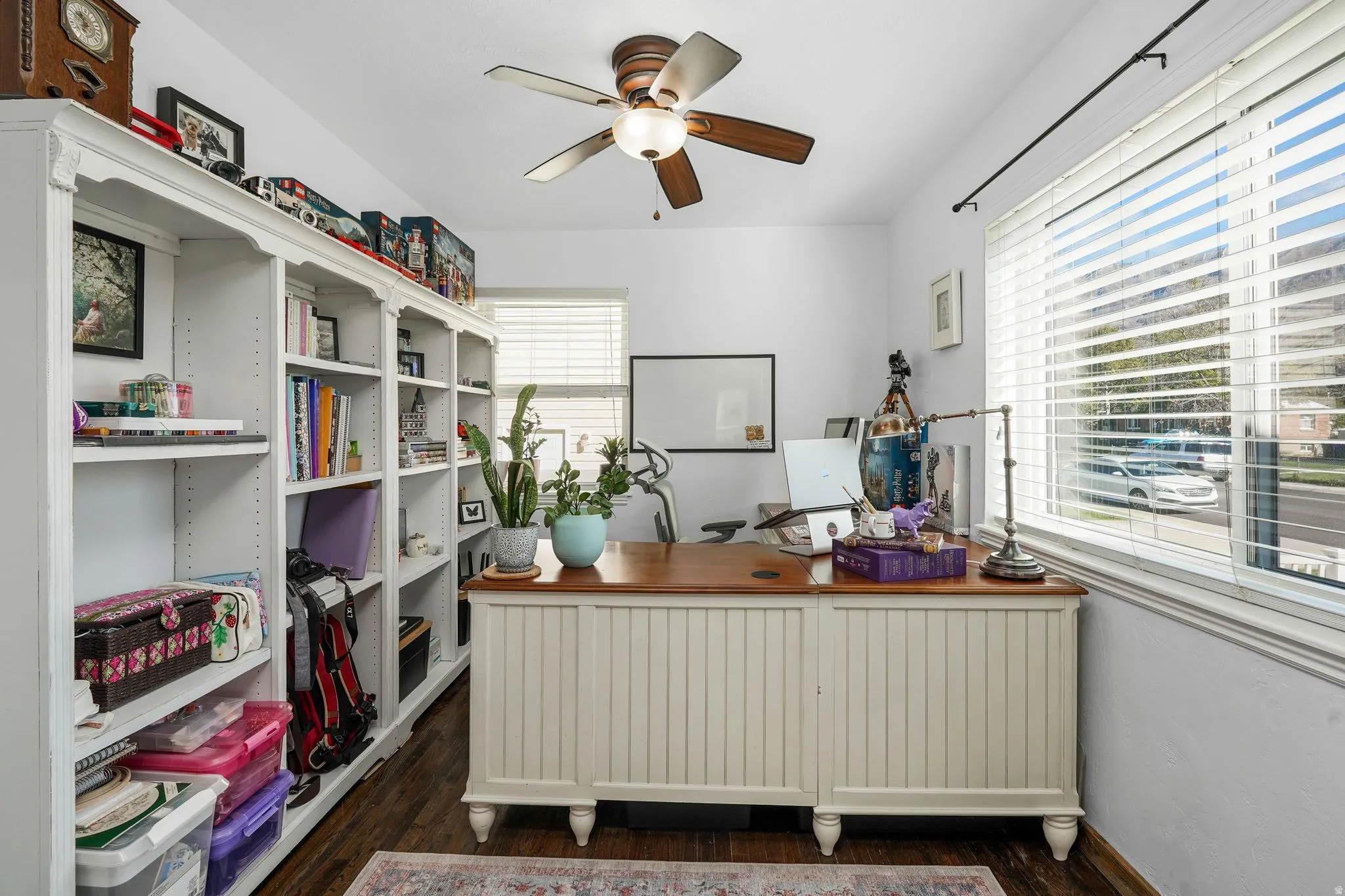 Office with dark wood finished floors, ceiling fan, and radiator heating unit