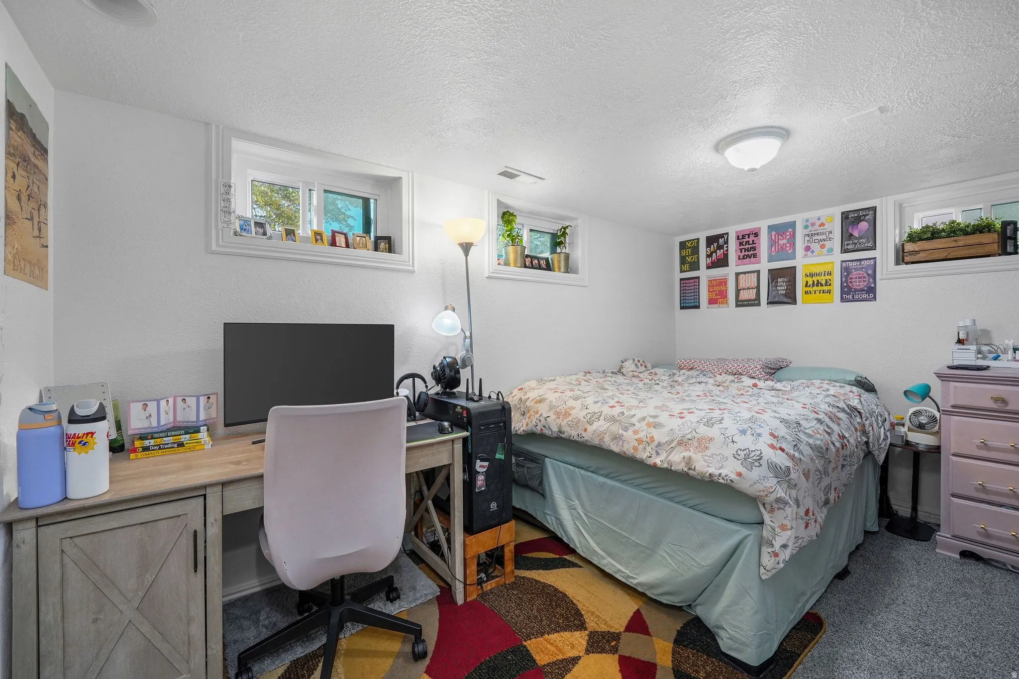 Bedroom with a textured ceiling, a desk, and carpet floors