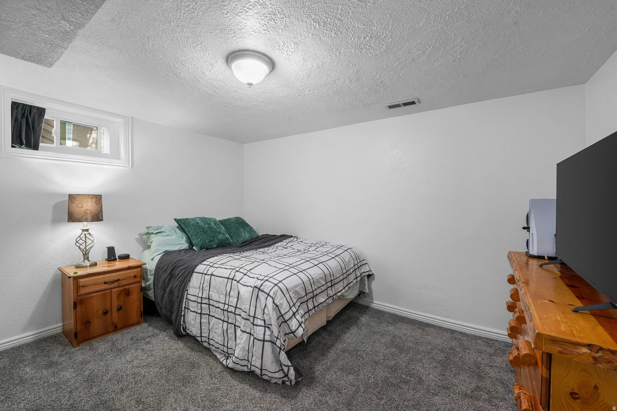 Bedroom with a textured ceiling and carpet floors
