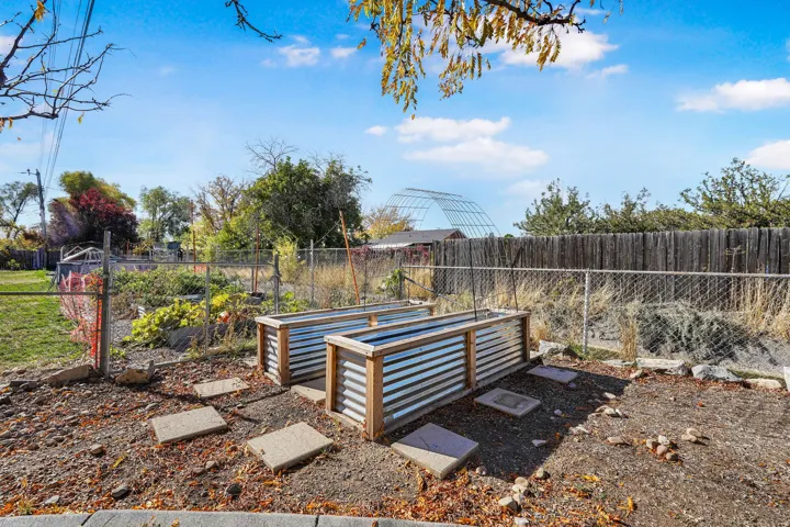 Fenced backyard featuring a vegetable garden