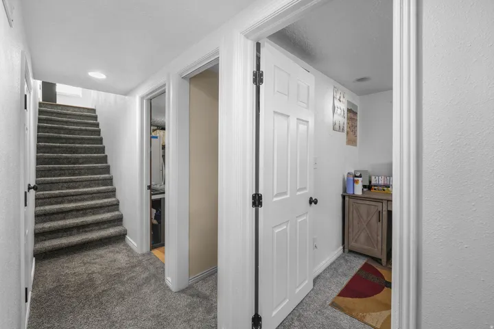 Hallway with light carpet and a textured ceiling