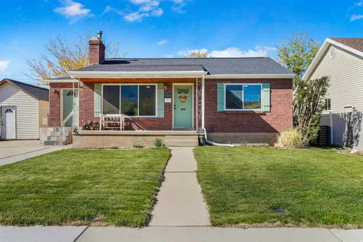 Bungalow with brick siding, a chimney, and a shingled roof