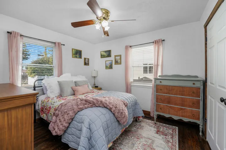 Bedroom with a ceiling fan, dark wood finished floors, and a closet