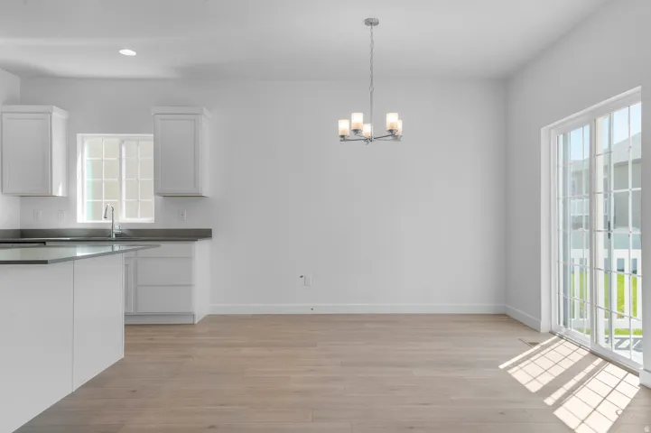 Unfurnished dining area with light wood-type flooring and a chandelier