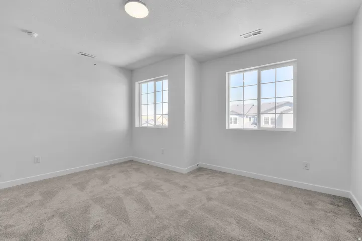 Unfurnished room with light colored carpet and a textured ceiling