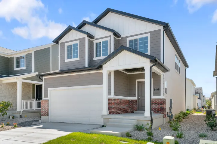 Craftsman house featuring a garage, covered porch, concrete driveway, board and batten siding, and brick siding