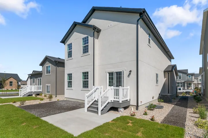 Rear view of property featuring stucco siding and a lawn
