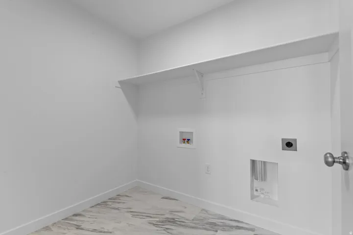 Laundry room with electric dryer hookup, washer hookup, and marble look tile flooring