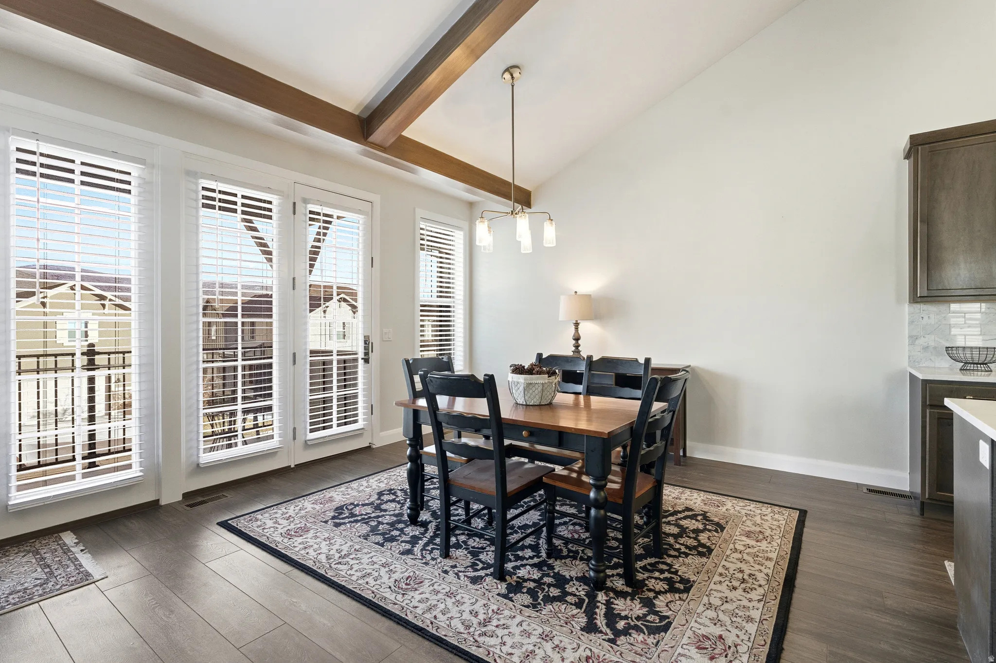 Dining area featuring lofted ceiling and dark wood-style flooring