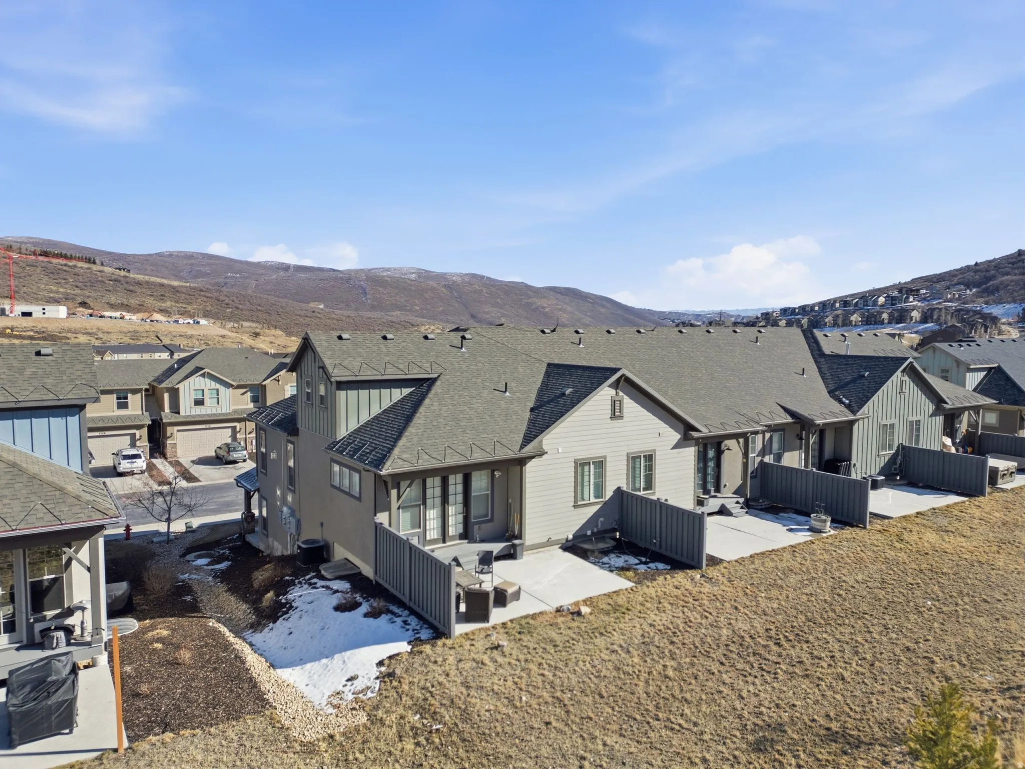 Rear view of house with a patio, a mountain view, a residential view, and a shingled roof