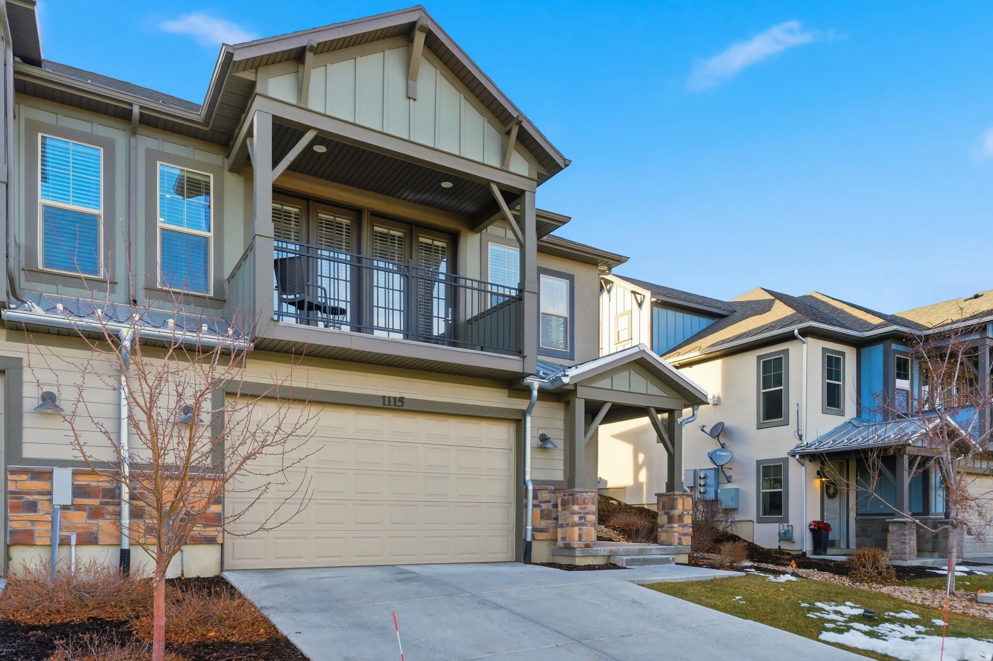 Craftsman-style house featuring a garage, concrete driveway, a balcony, board and batten siding, and stucco siding
