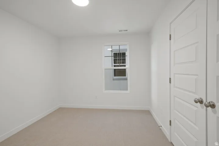 Unfurnished room with light carpet and baseboards