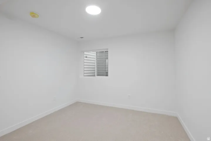 Unfurnished room featuring carpet floors and a smoke detector