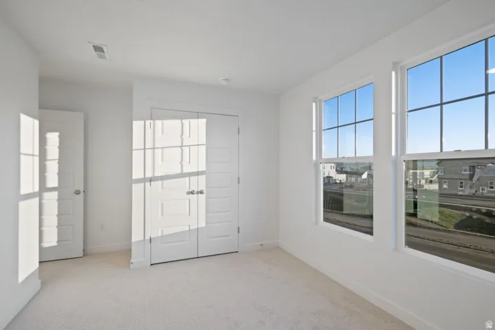 Spare room with light carpet and baseboards