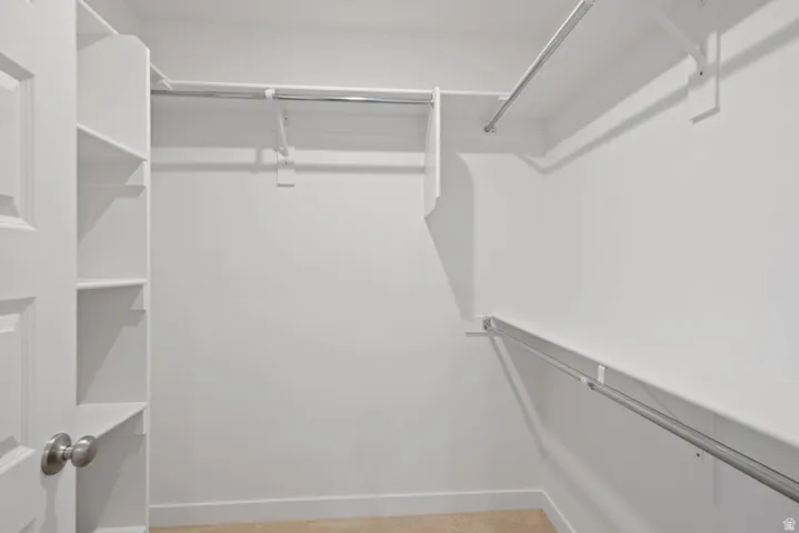 Walk in closet with light carpet