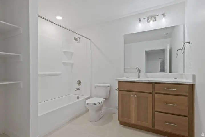 Bathroom featuring vanity,  shower combination, and light tile patterned floors