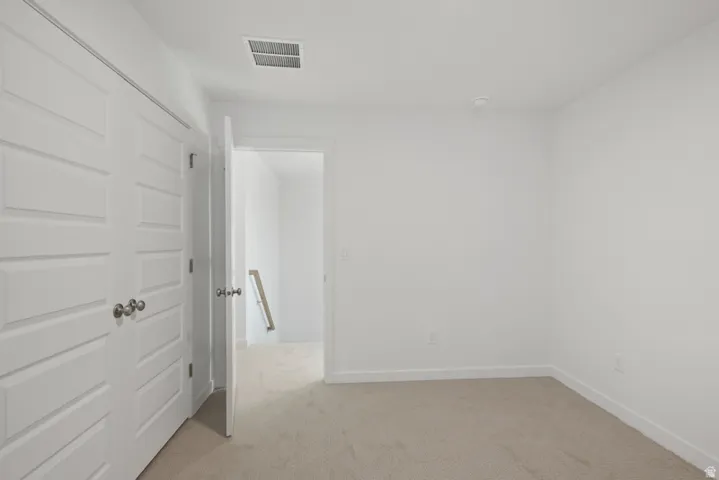Spare room with light carpet and baseboards