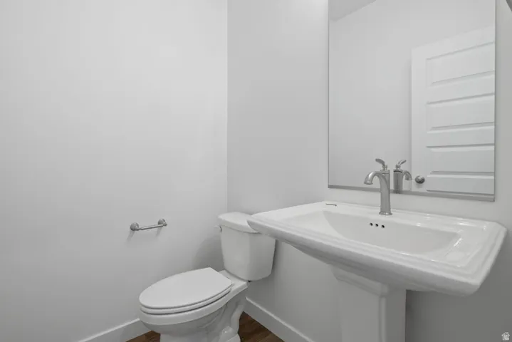 Bathroom featuring baseboards and dark wood-style floors