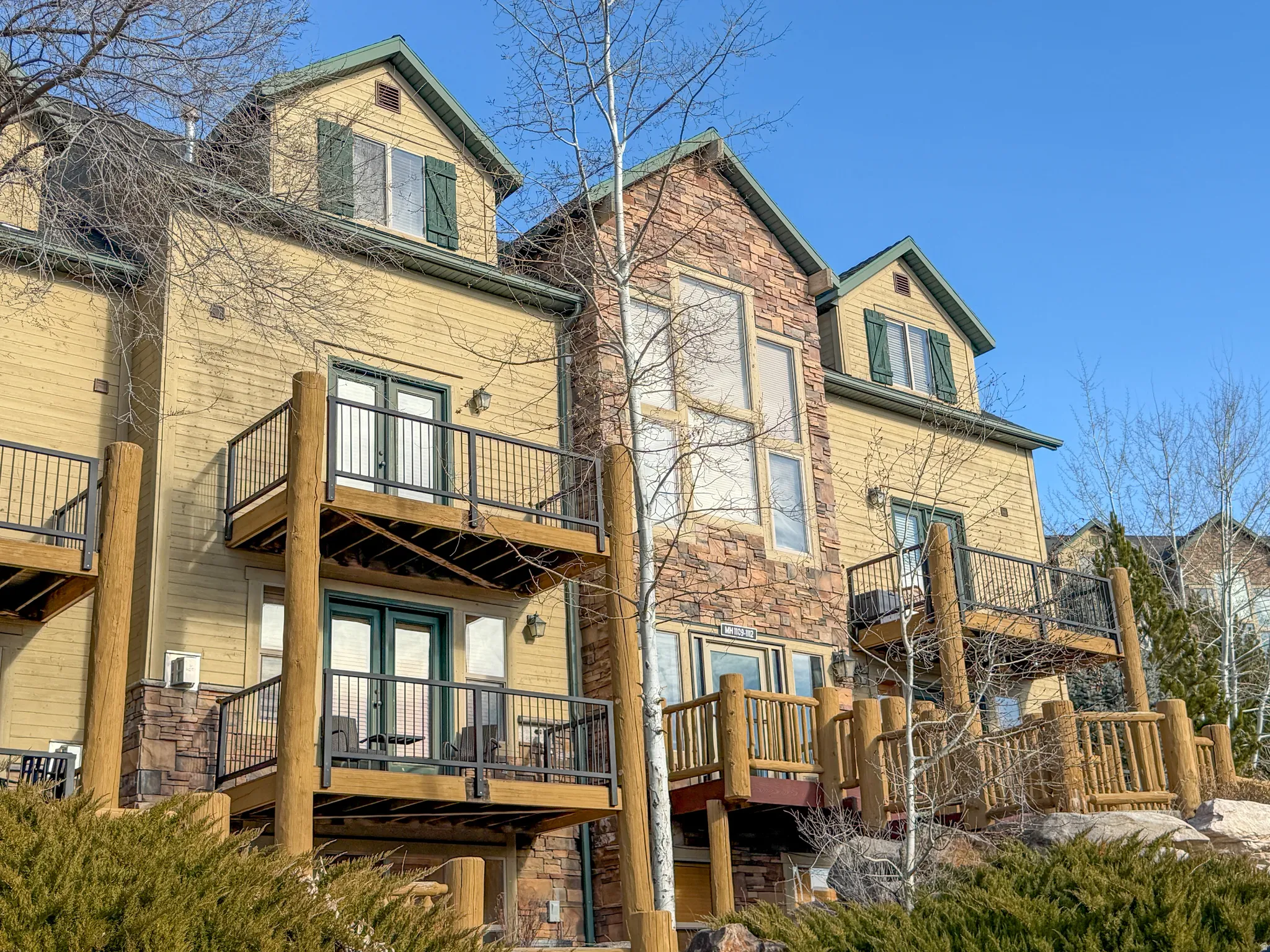 Rear view of property with stone siding