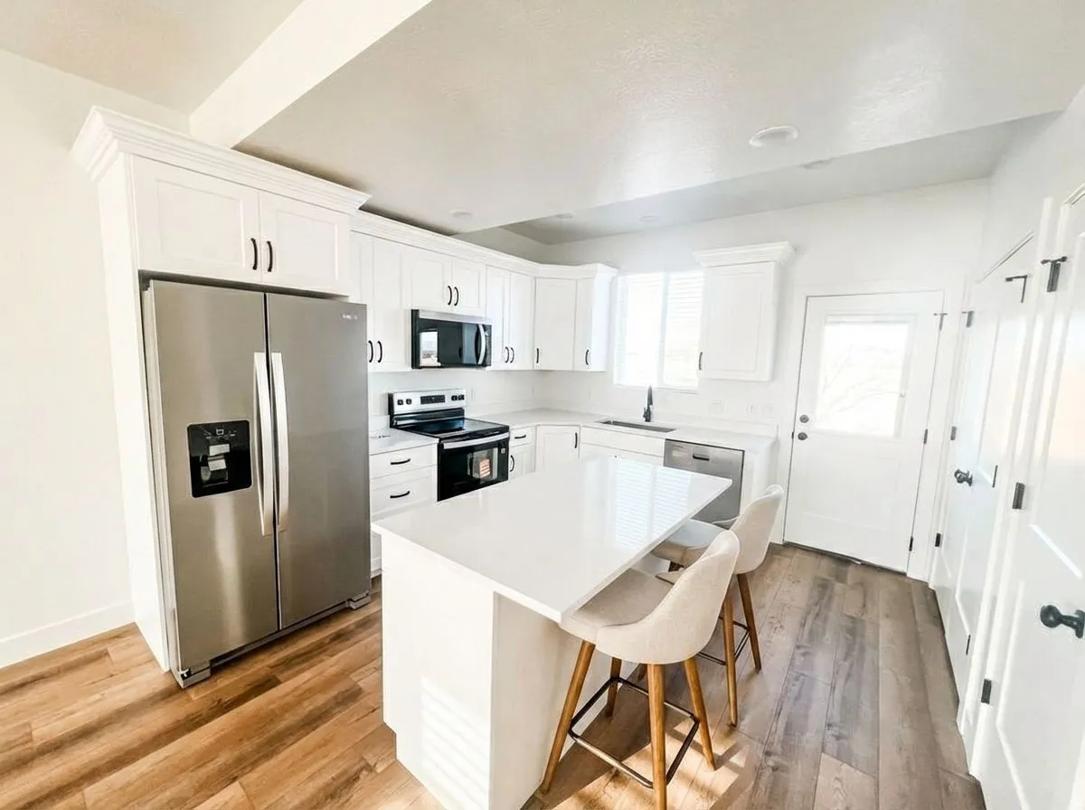 Kitchen featuring stainless steel appliances, a breakfast bar, white cabinets, a center island, and light wood-type flooring