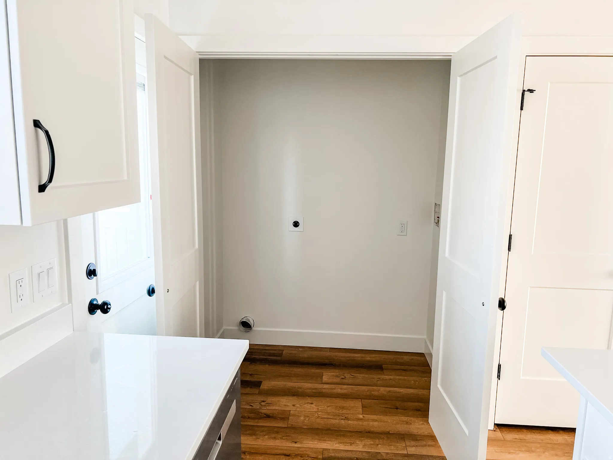 Laundry area with dark wood-style floors and hookup for an electric dryer