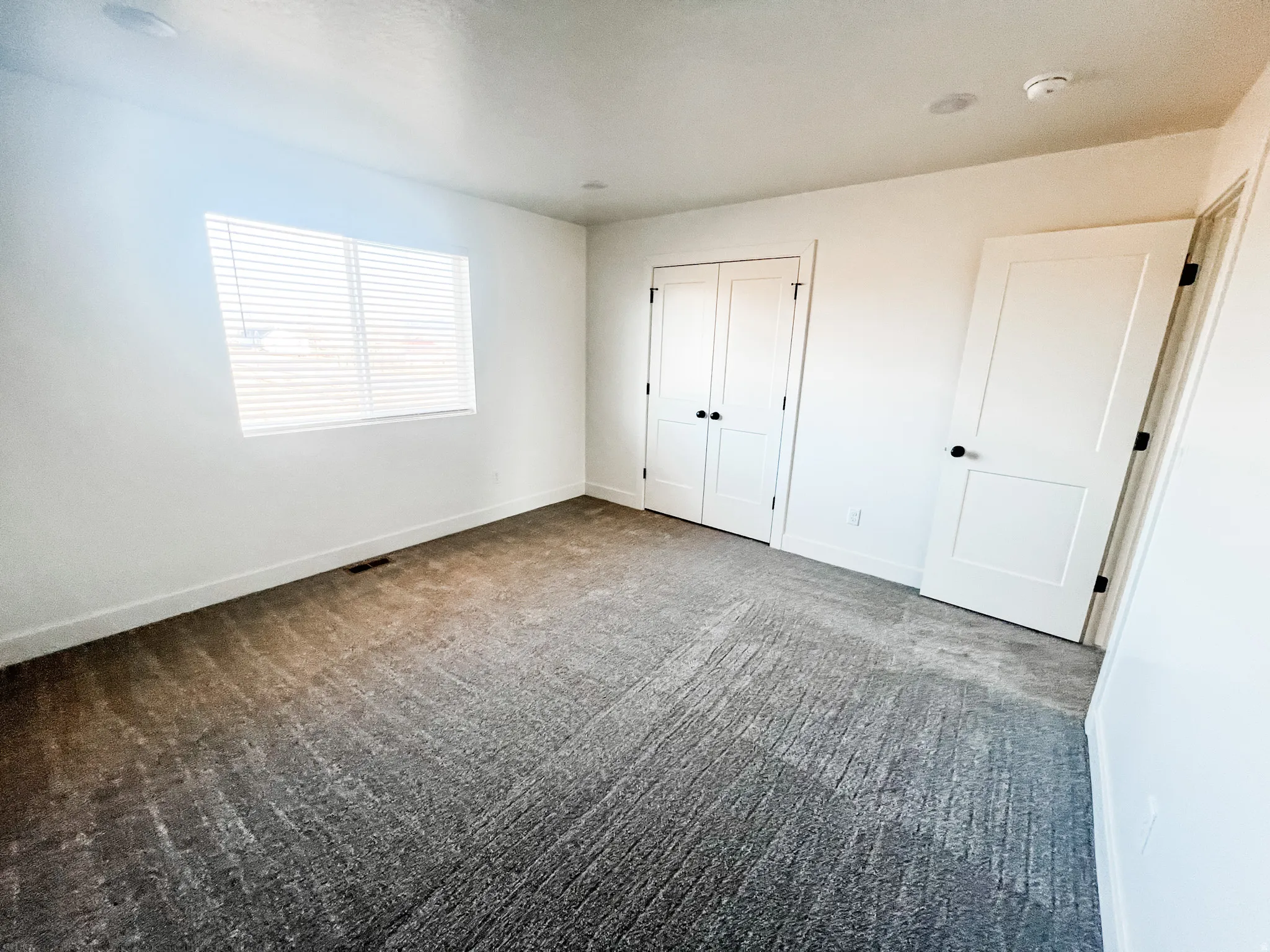 Unfurnished bedroom with dark carpet and a closet