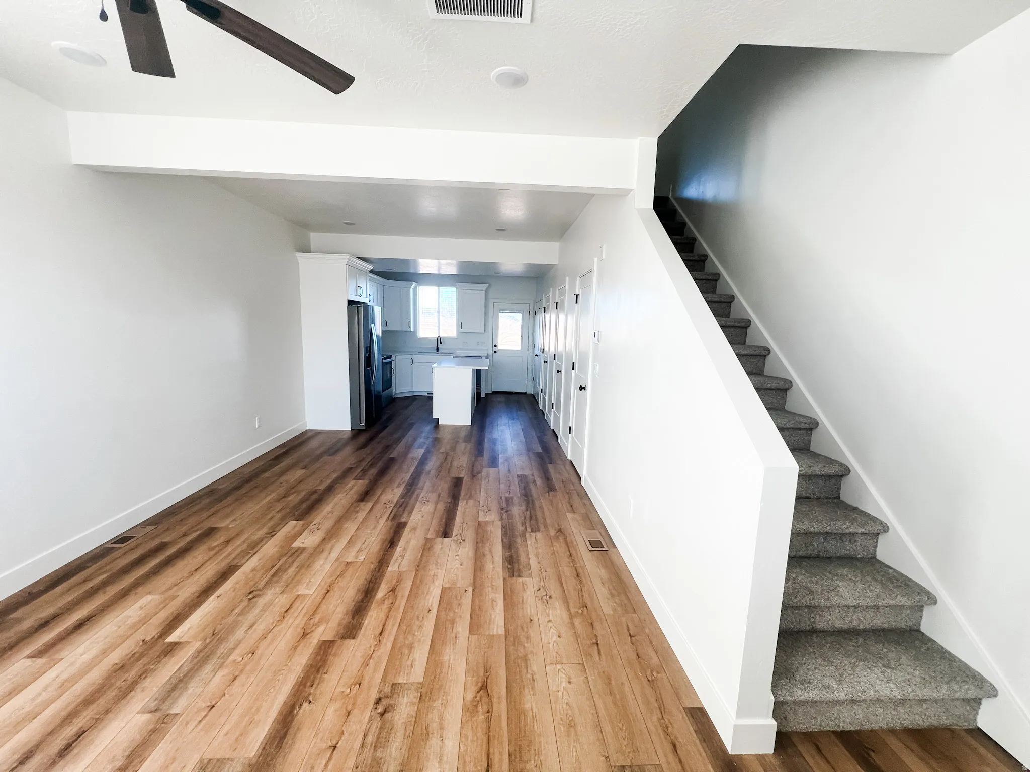 Unfurnished living room with dark wood-style floors and baseboards