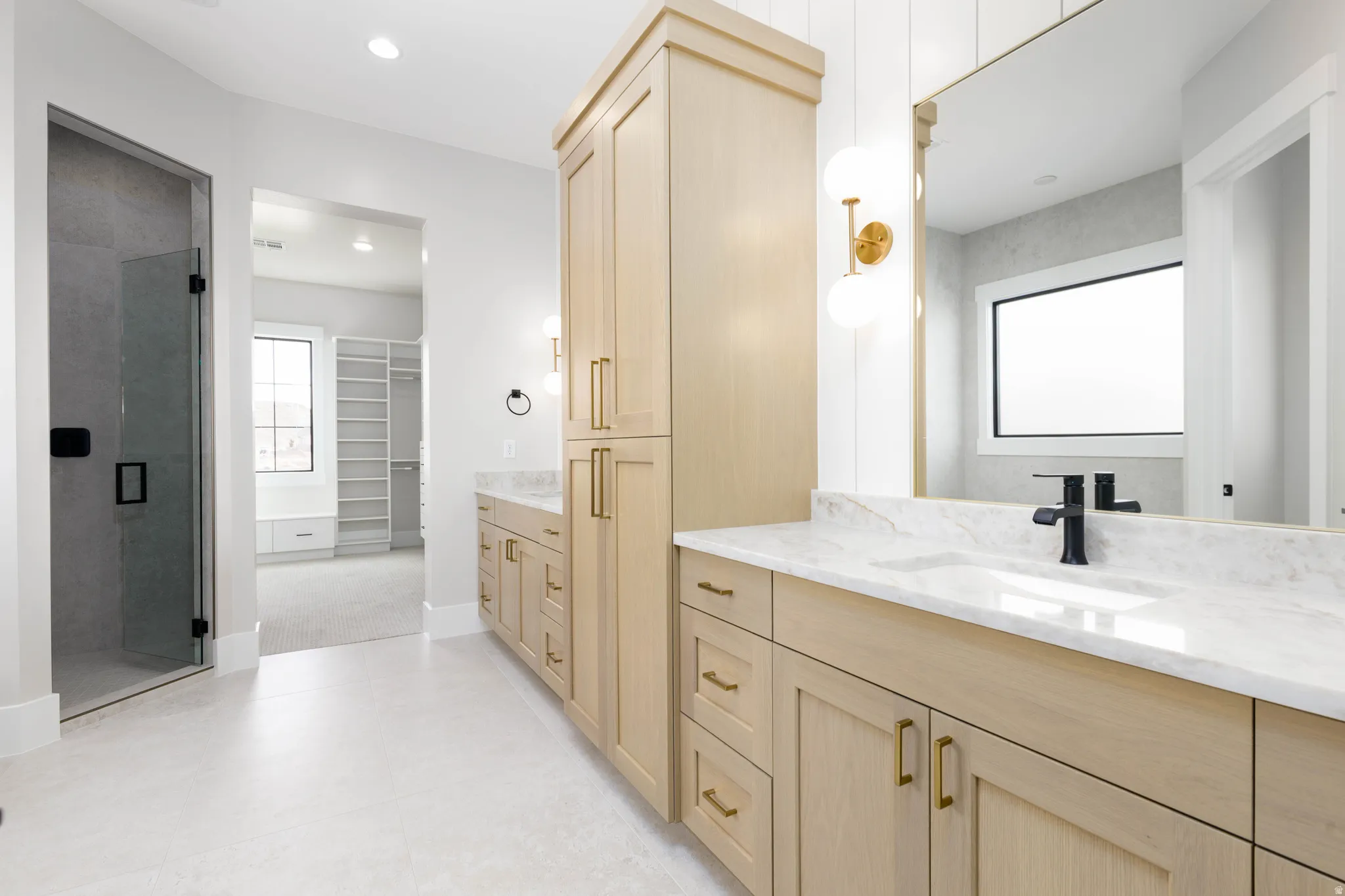 Full bathroom with a spacious closet, two vanities, a shower stall, and recessed lighting
