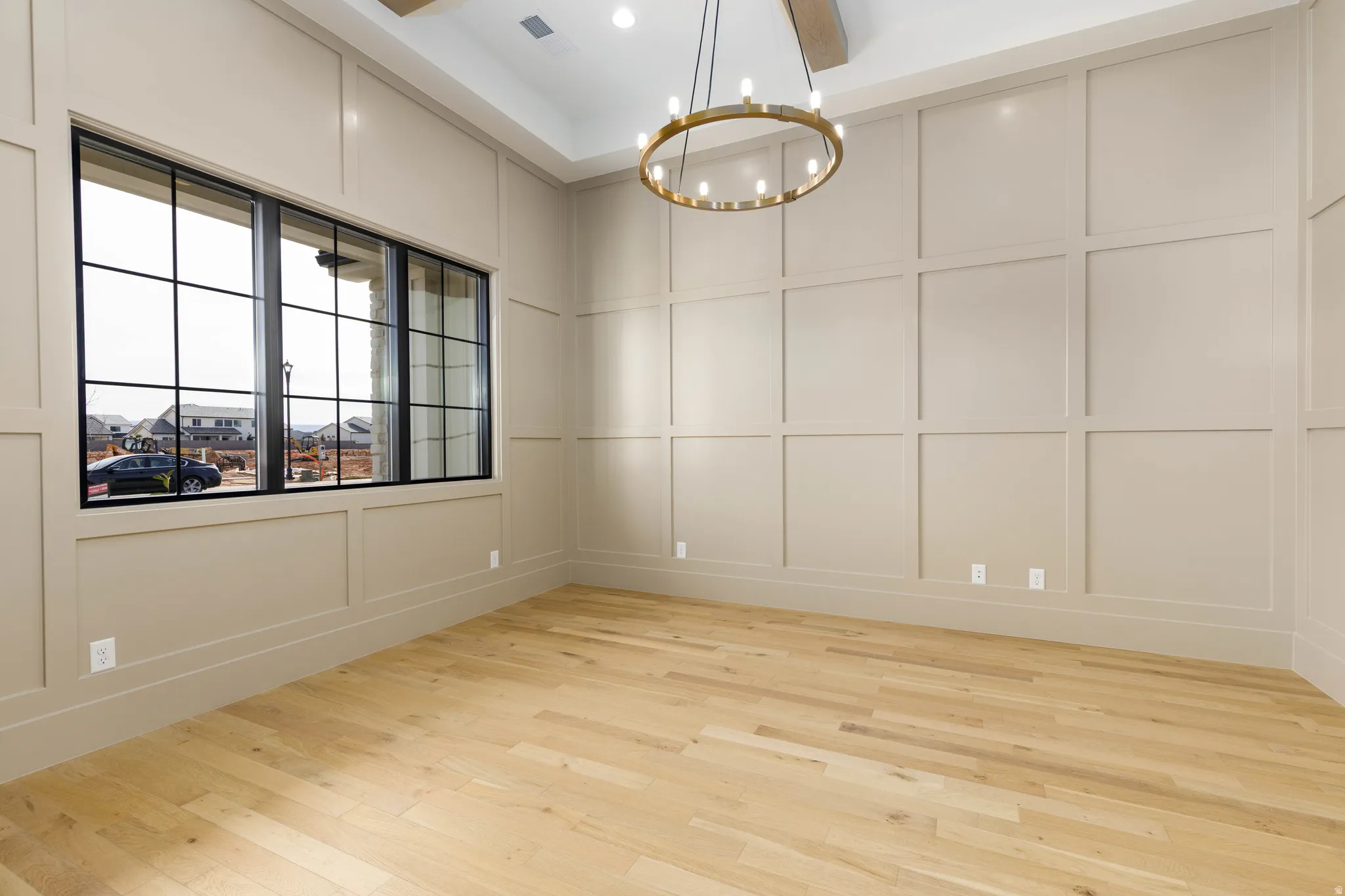 Spare room featuring a decorative wall, a chandelier, and light wood-style floors