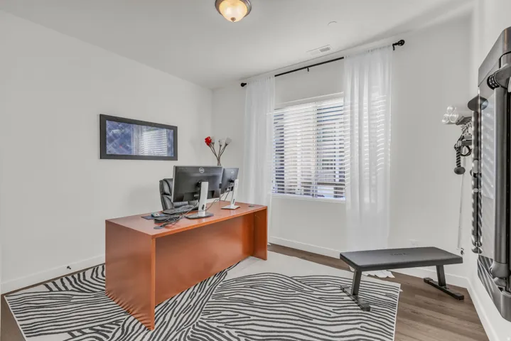 Home office with baseboards and wood finished floors