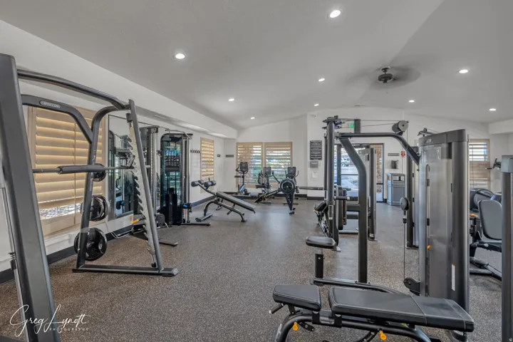 Exercise room with lofted ceiling, a ceiling fan, and recessed lighting