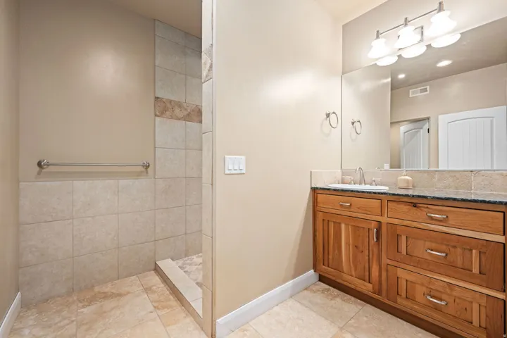 Bathroom with vanity, light tile patterned floors, and a walk in shower