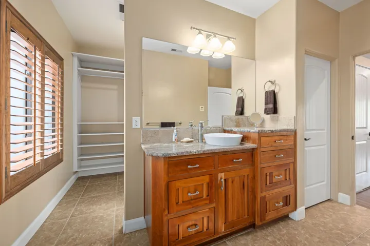 Bathroom featuring a spacious closet, vanity, and light tile patterned floors