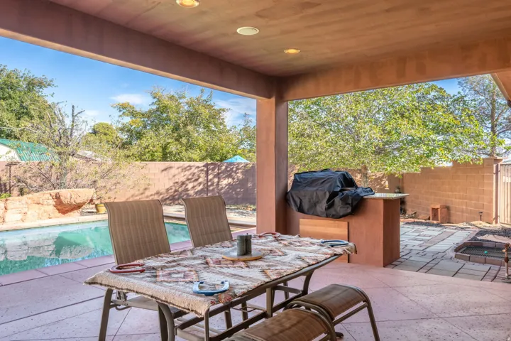 Fenced backyard with a patio, a grill, and outdoor dining space