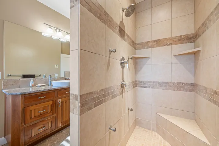 Full bathroom featuring a tile shower and vanity